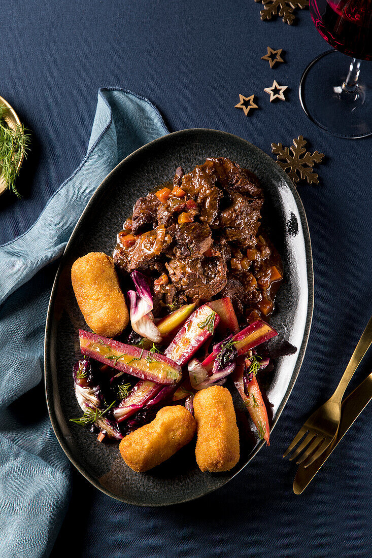 Hirschgulasch mit bunten Möhren, Radicchio und Kroketten