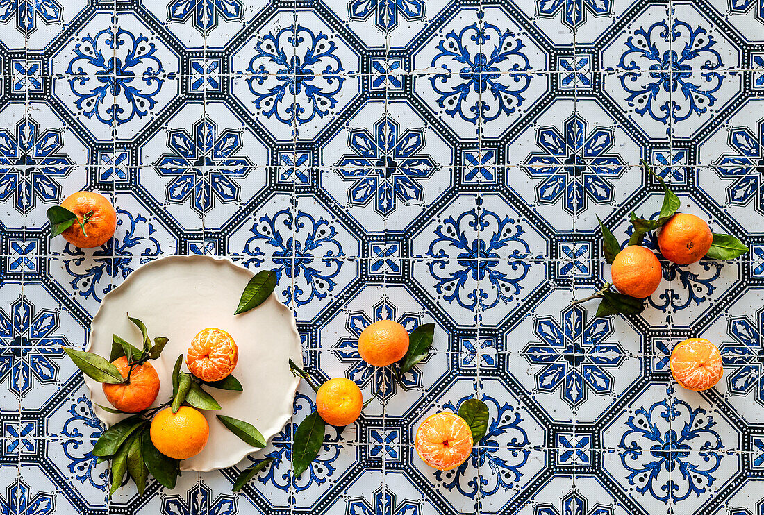 Clementines from Spain with leaves on a tile background