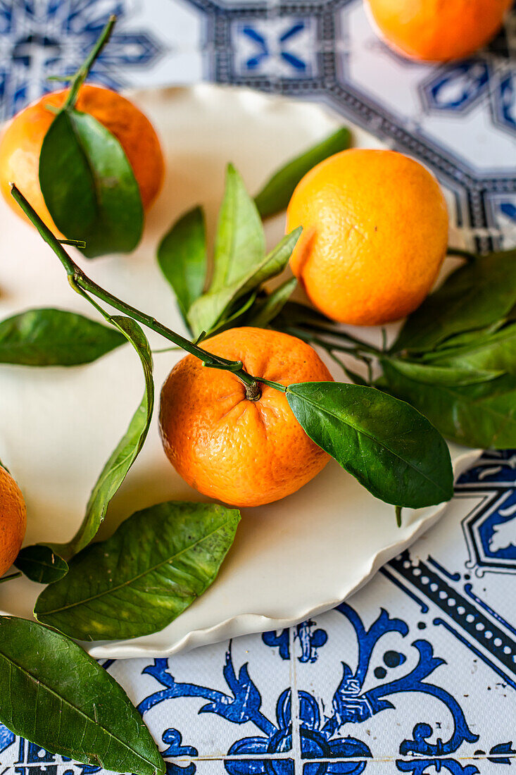 Clementines from Spain with leaves on a tiled background
