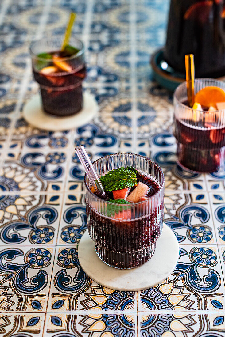 Sparkling wine sangria with glass straws on Portuguese tiles