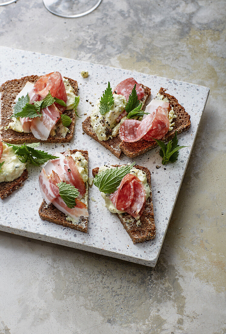 Black bread variations with egg spread, nettle butter, ham and salami