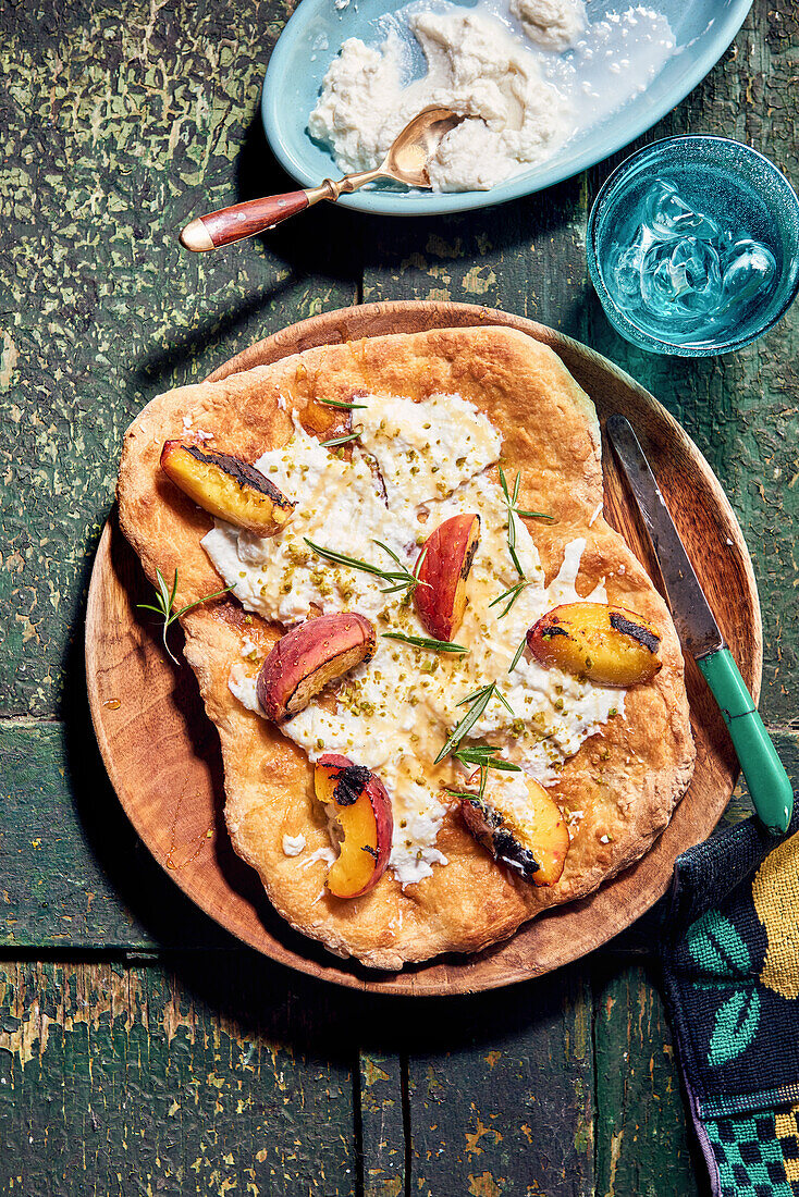 Pizza with grilled peach, ricotta, pistachios and rosemary