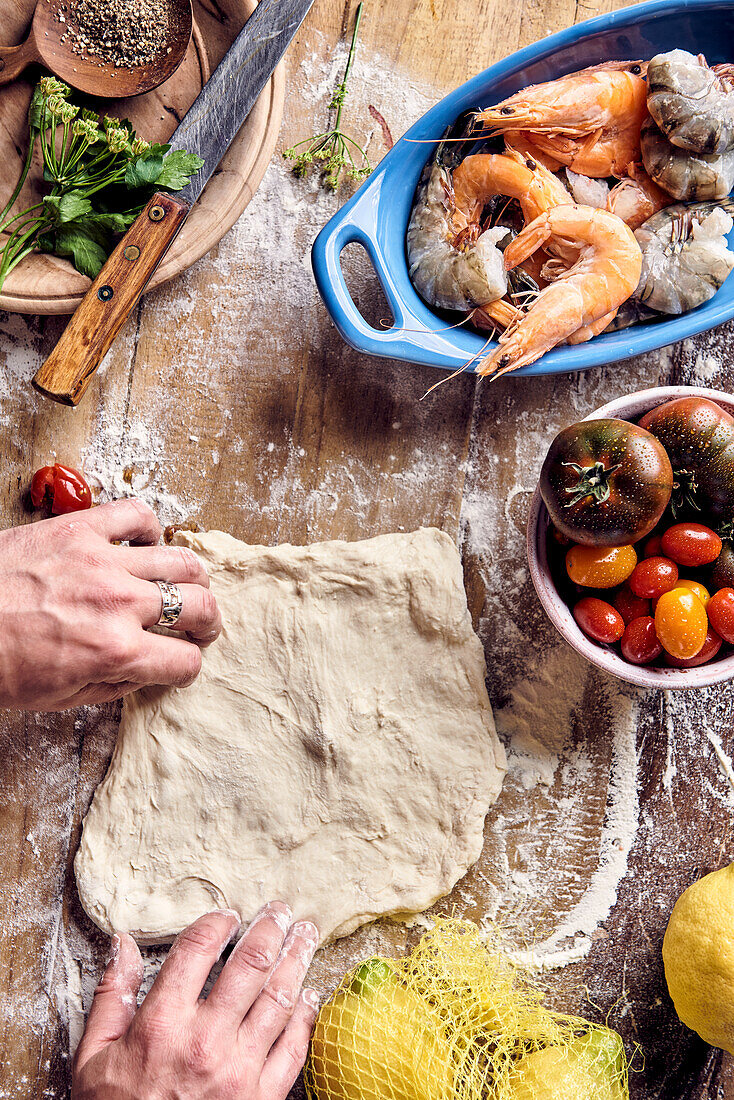 Preparing pizza with prawns and tomatoes - Shaping pizza dough