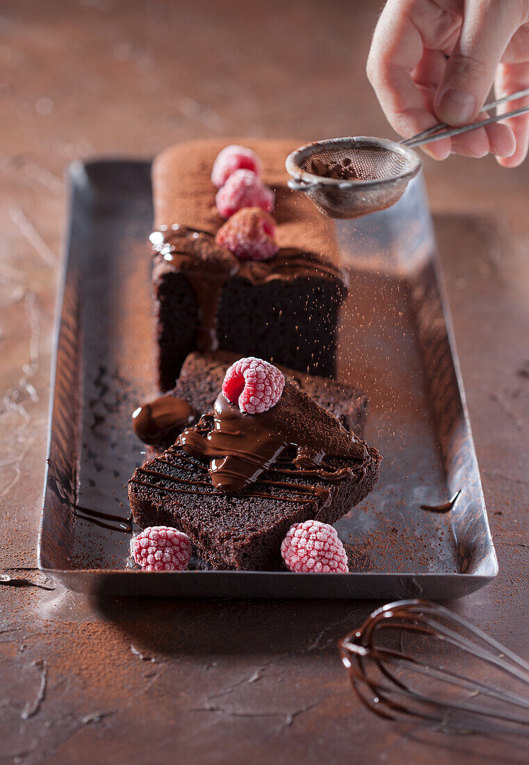 Chocolate cake with chocolate sauce and iced raspberries