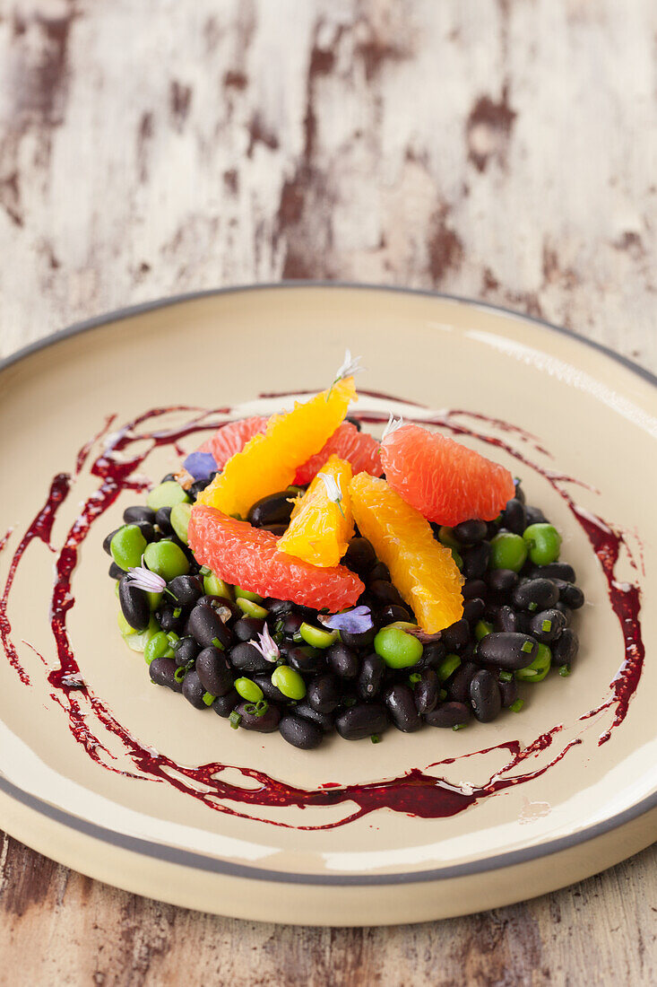 Black bean salad with peas, citrus fruits and beetroot sauce