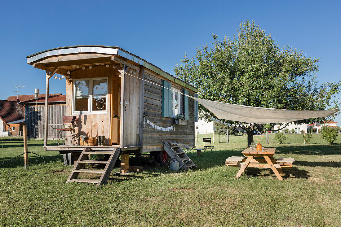 Refurbished caravan, in front of it terrace with awning in the garden