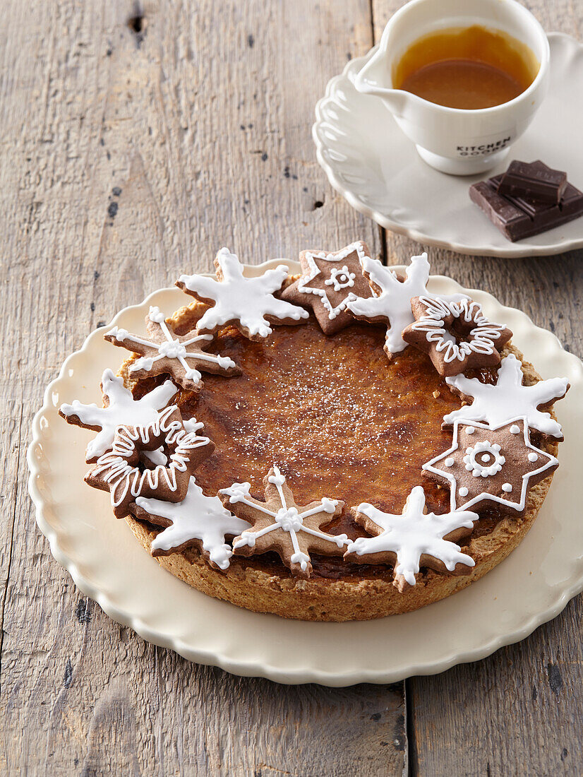 Schokoladen-Karamell-Weihnachtstorte mit Lebkuchenplätzchen dekoriert