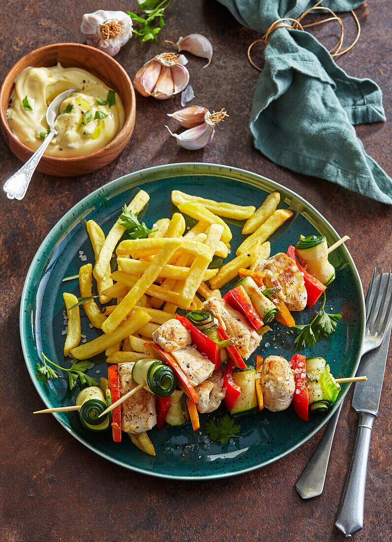 Chicken skewers with zucchini rolls and fries