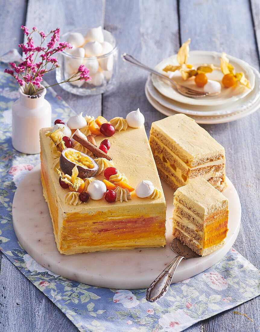 Cinnamon cake decorated with fruit and meringue dots