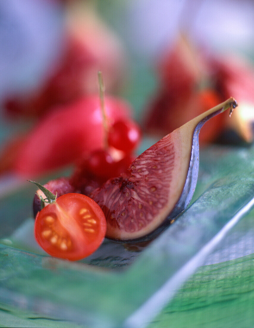 A fig with a tomato and redcurrants