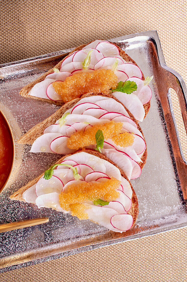 Open sandwiches topped with radishes and hake caviar