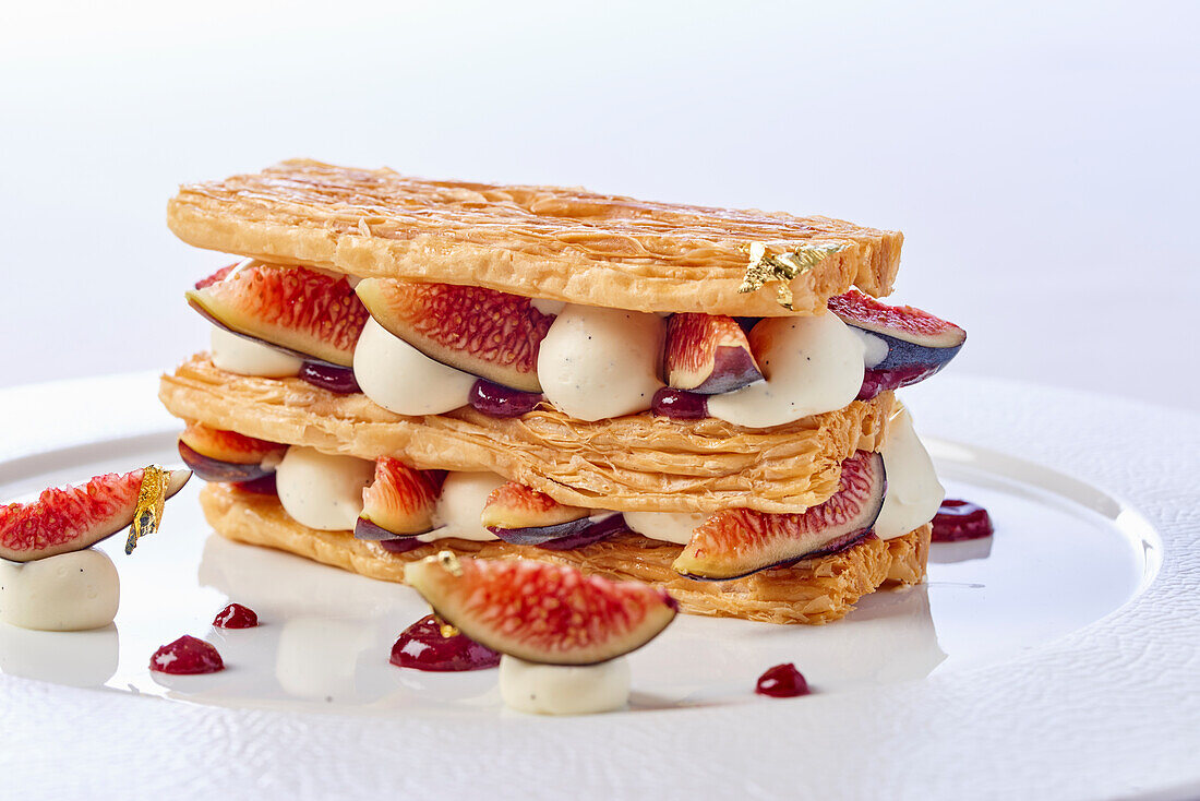 A mille feuille with figs, vanilla cream and gold leaf