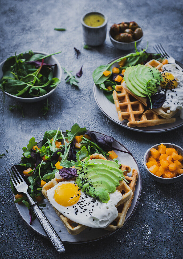 Waffles with fried egg, avocado and yellow pepper salad