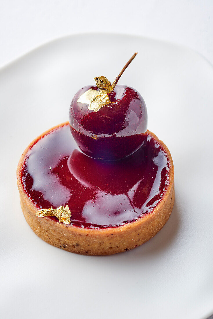 Red wine and cherry tartlet with gold leaf