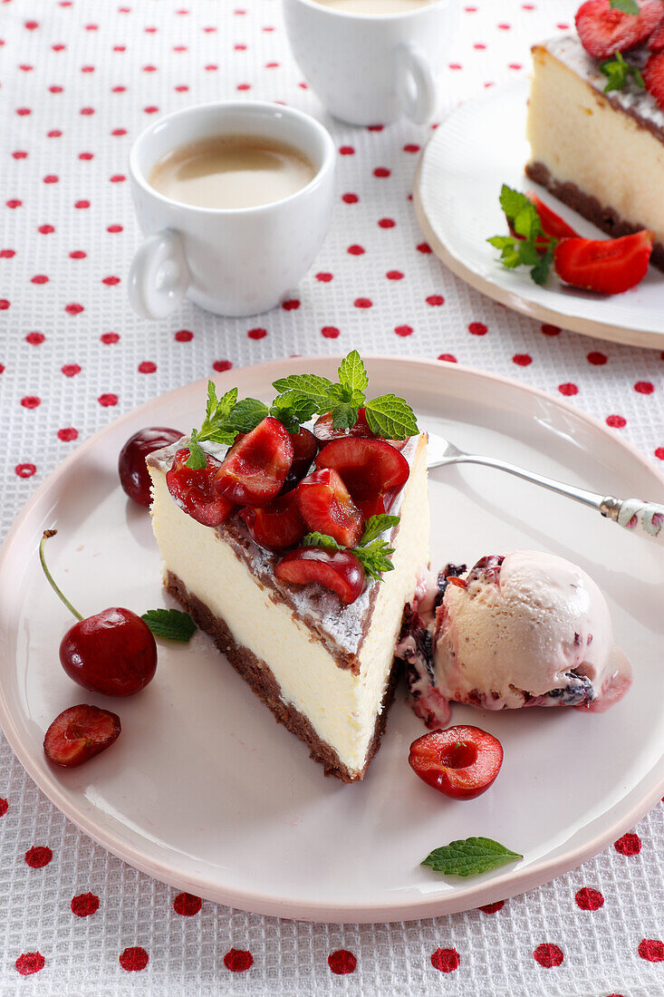 A piece of cheesecake decorated with cherries, served with an ice cream scoop