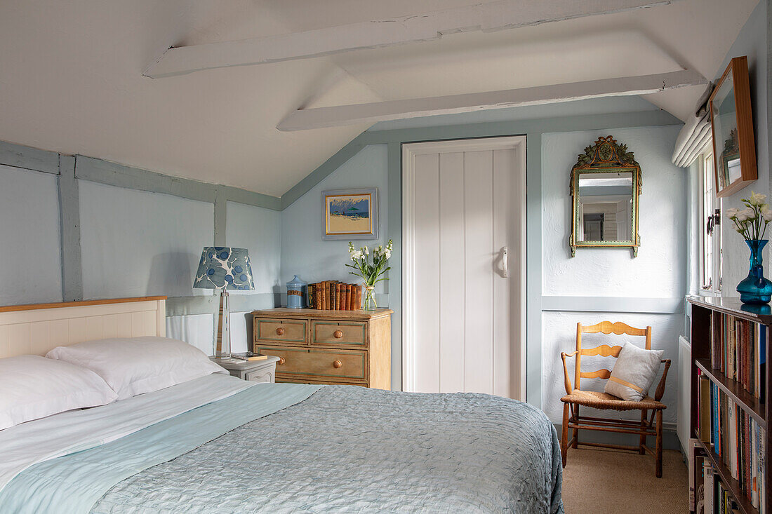 Doppelbett und Kommode im Schlafzimmer in Hellblau und Weiß