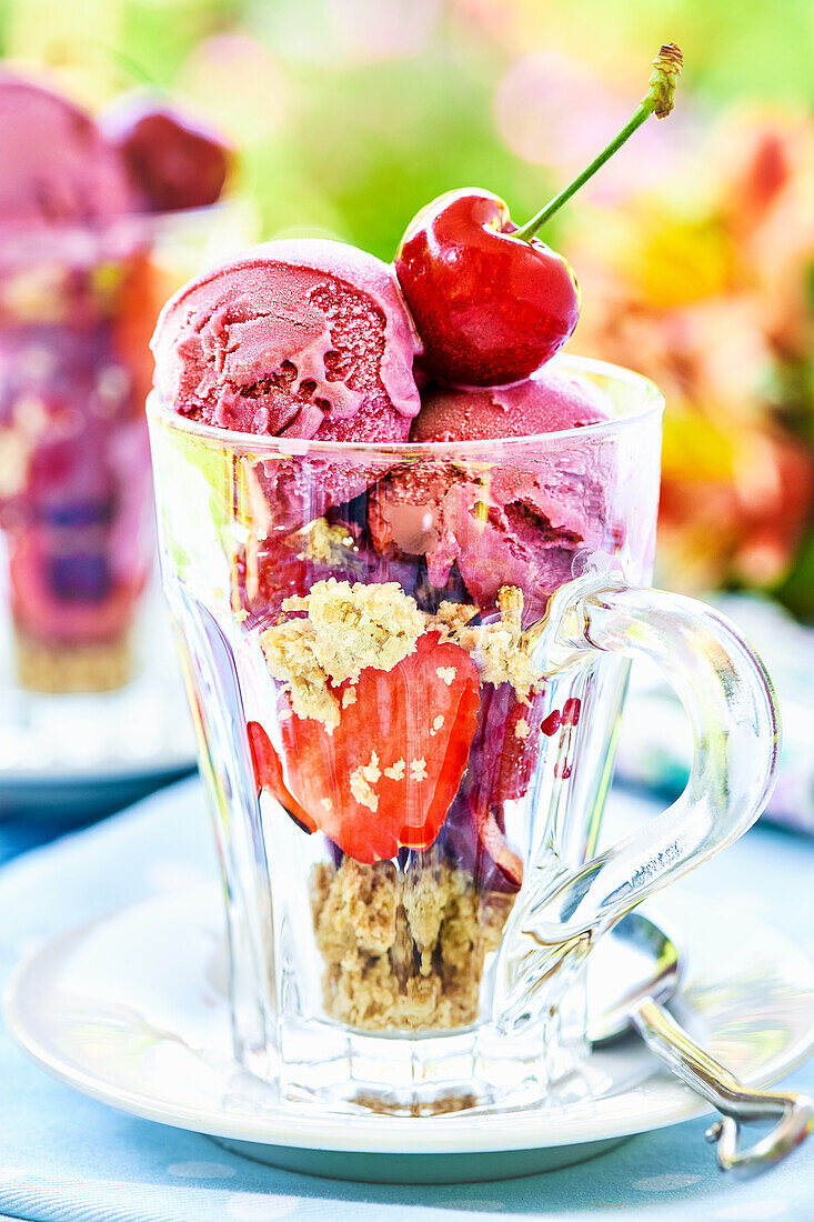 Sommerlicher Eisbecher mit Beeren und Kirsche