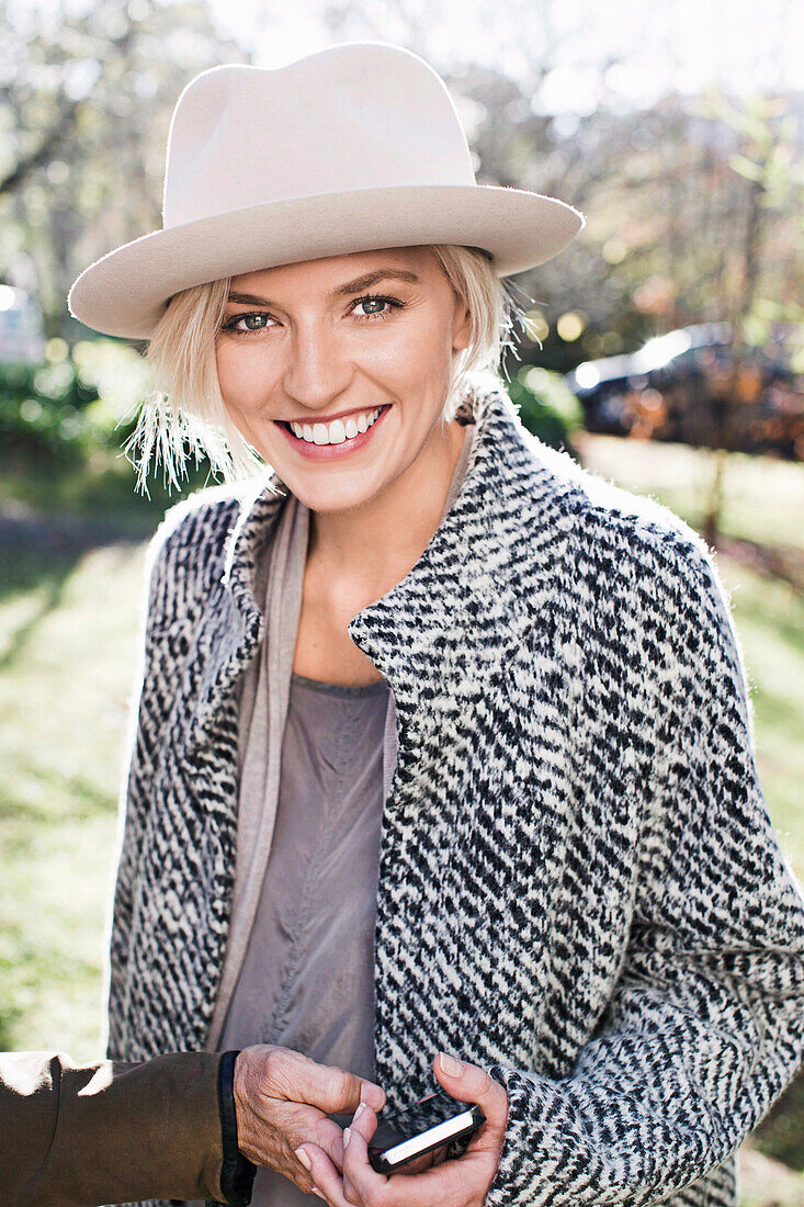 A blonde woman wearing a hat and a woollen coat