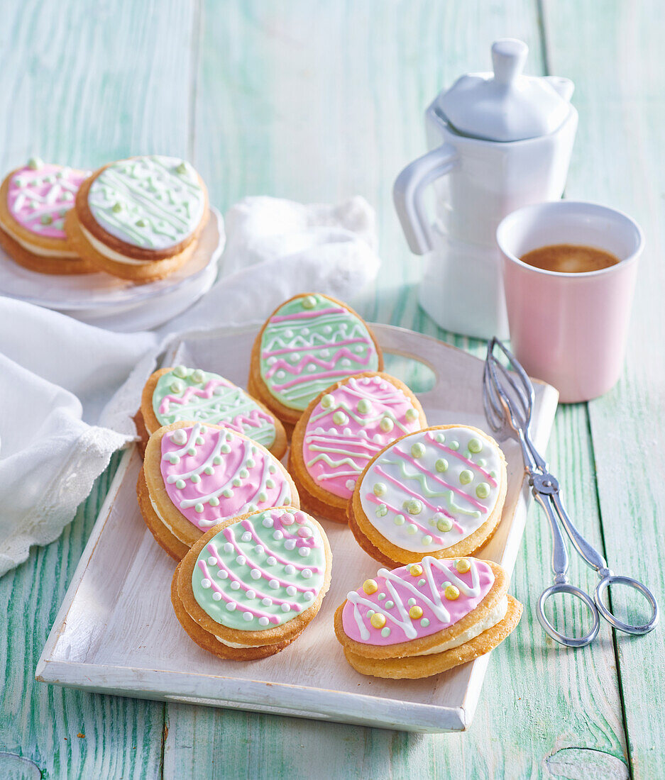 Coconut biscuits in the shape of Easter eggs with pastel-coloured icing