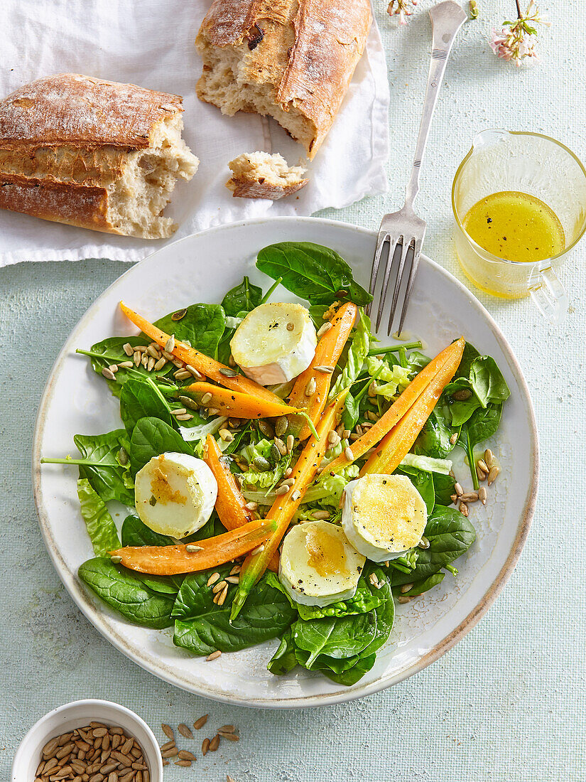 Spinach salad with goat cheese, carrots and sunflower seeds