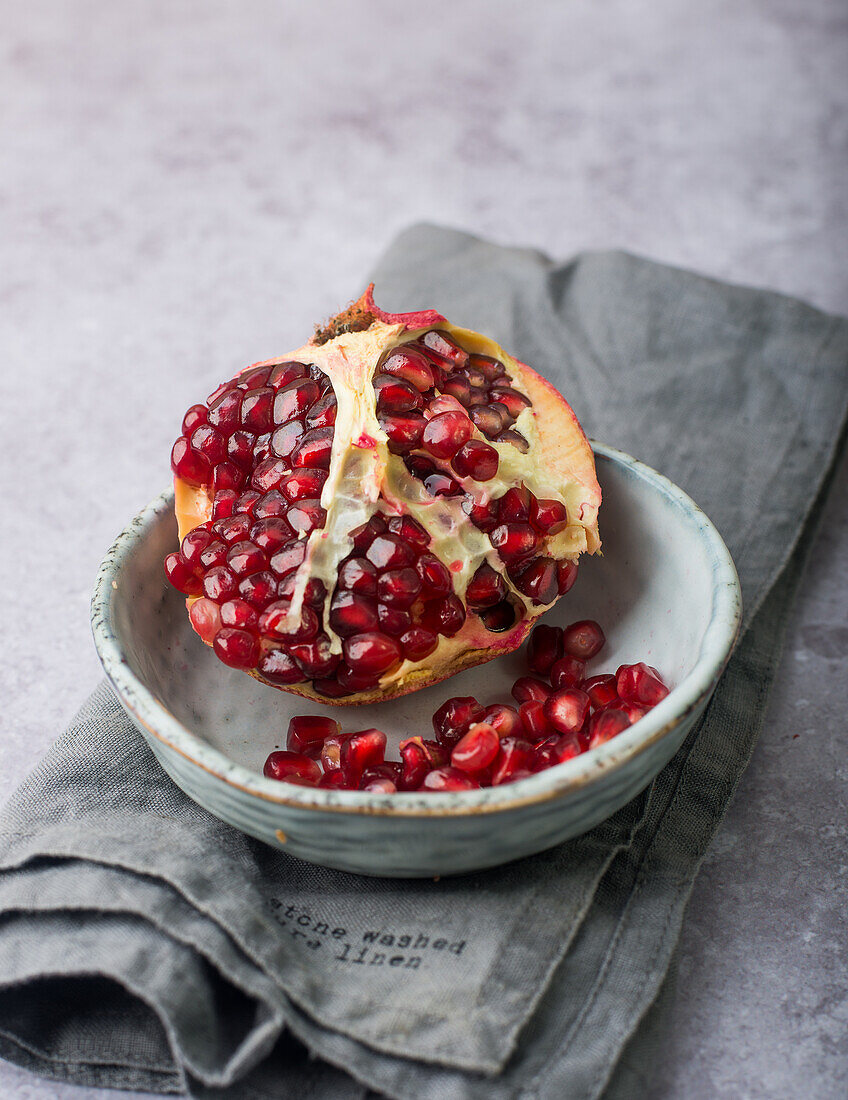 Aufgebrochener Granatapfel in Schale