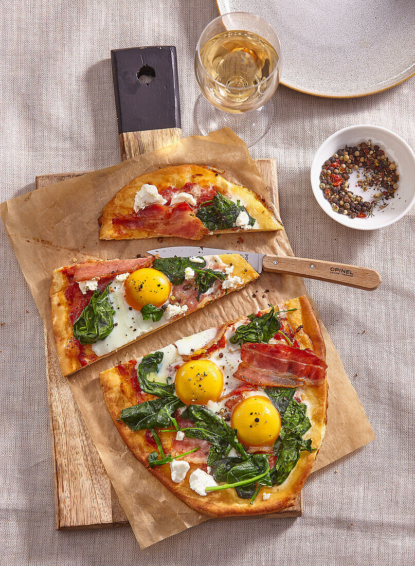 Pizza with bacon, spinach and eggs