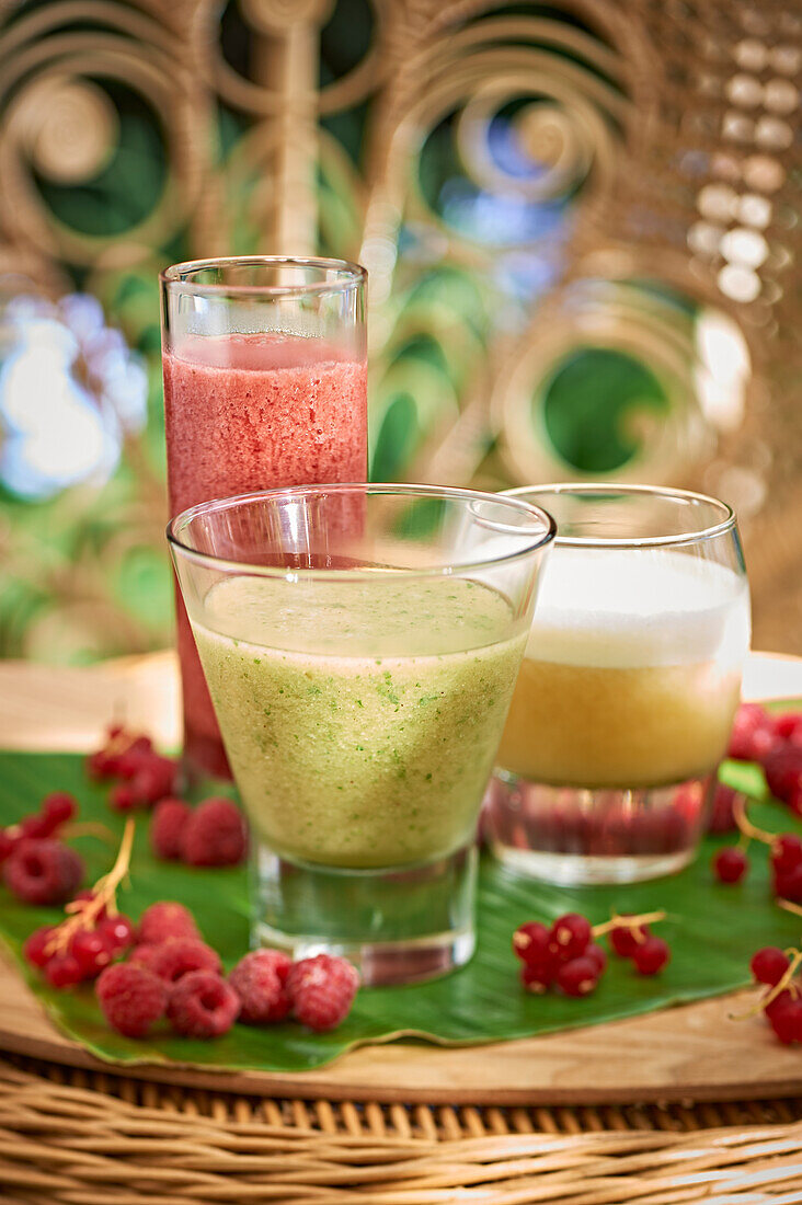 Verschiedene Smoothies drumherum Himbeeren und Johannisbeeren