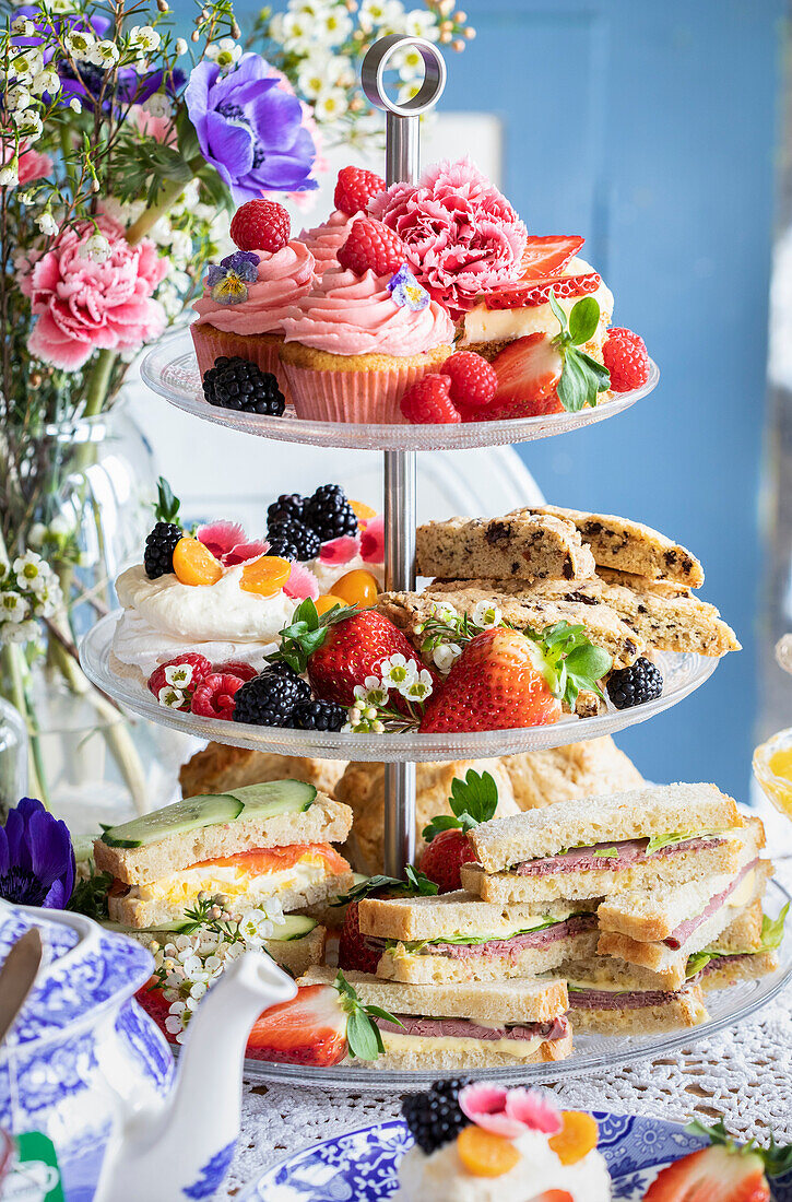 Tiered dessert stand with sandwiches and pastries