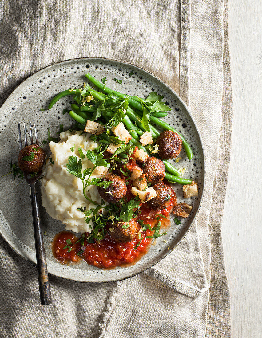 Vegetarian meatballs in tomato sauce with mashed potatoes and croutons