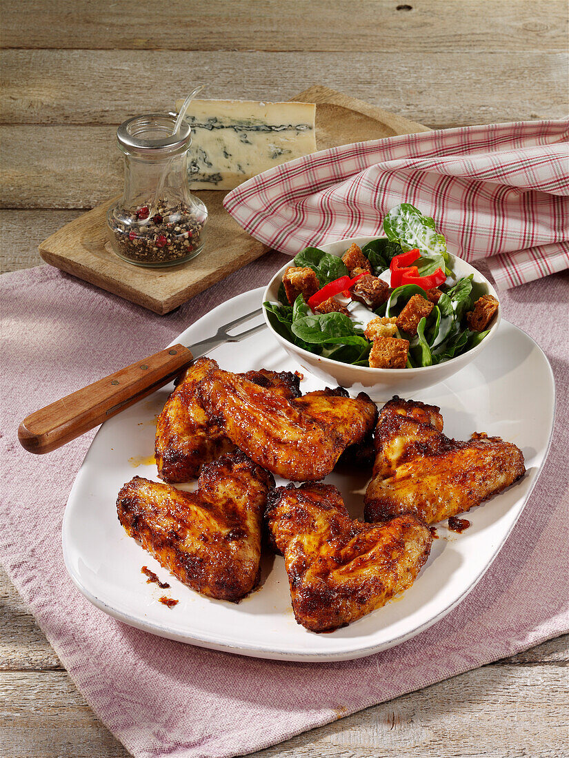 Chicken wings with spinach salad