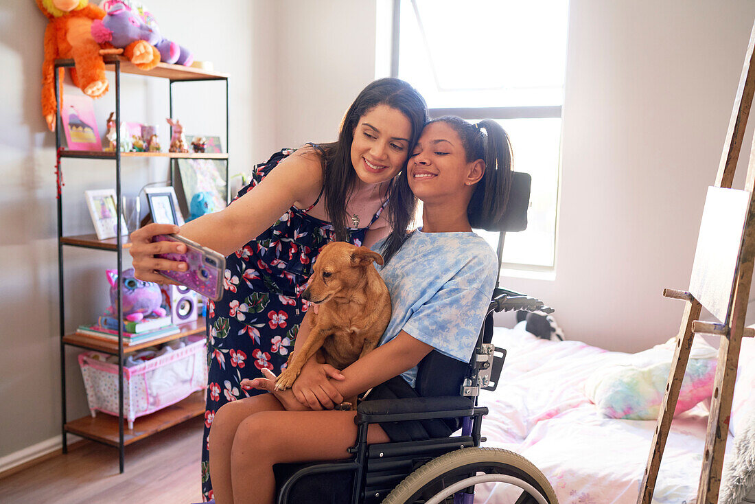 Happy mum and disabled daughter with dog taking selfie