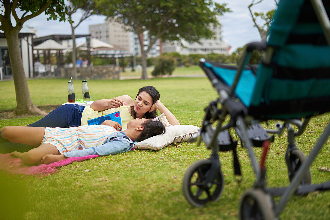 Mother and disabled daughter laying and talking in park