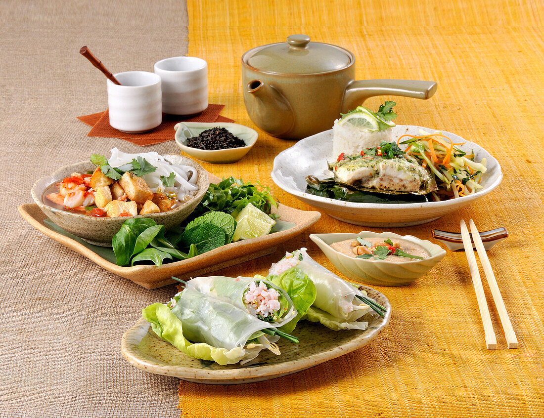 Thailändische Suppe mit Garnelen, Tofu und Reisnudeln sowie Sommerröllchen