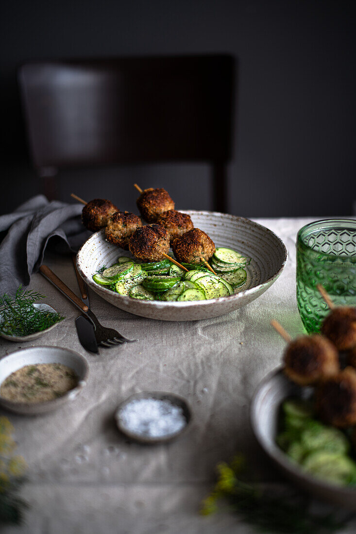 Meatballs on skewers with cucumber salad