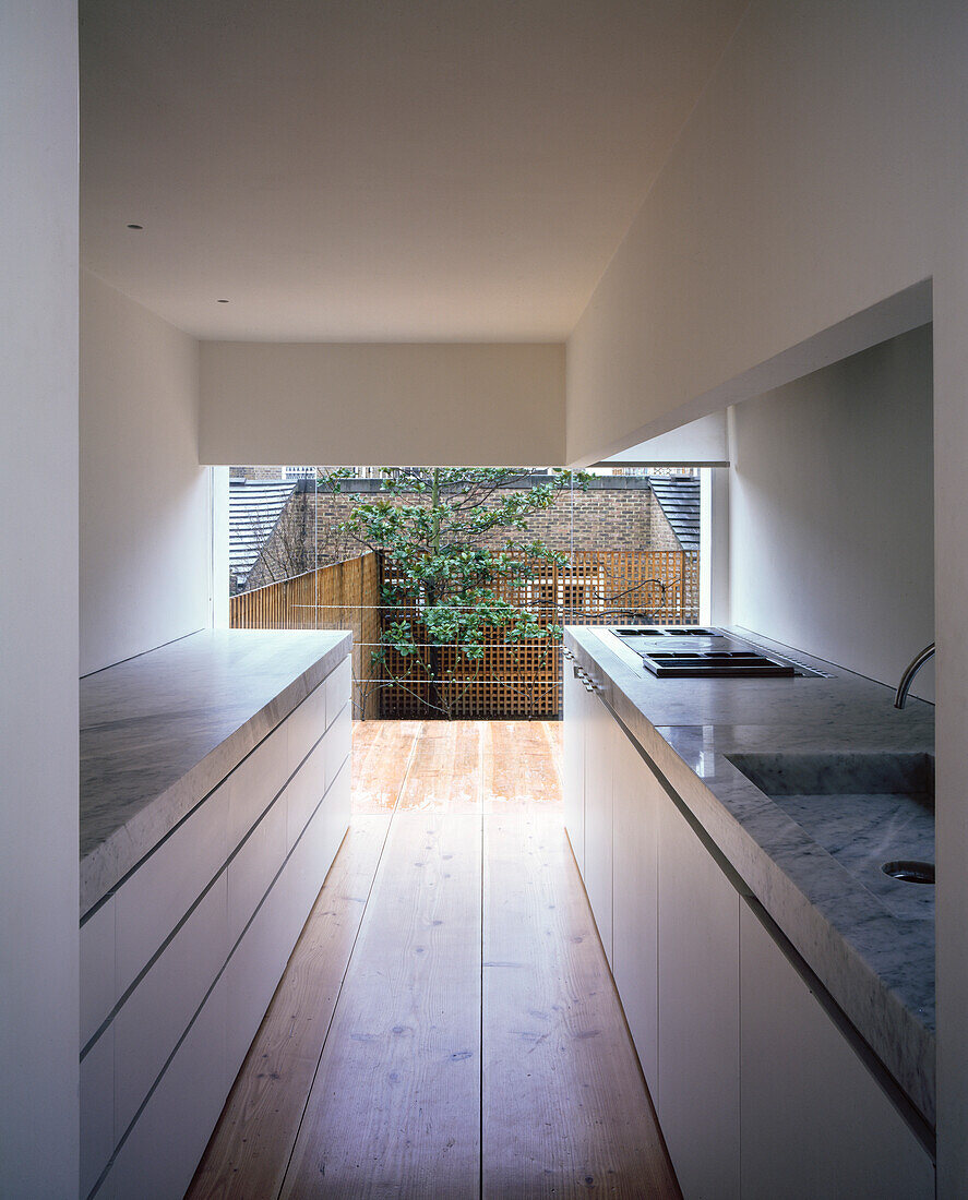 A minimalist kitchen with a floor-to-ceiling window