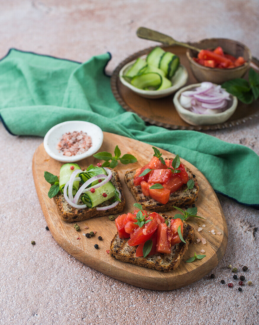 Grilled bread slices with fresh tomatoes, cucumbers and red onions