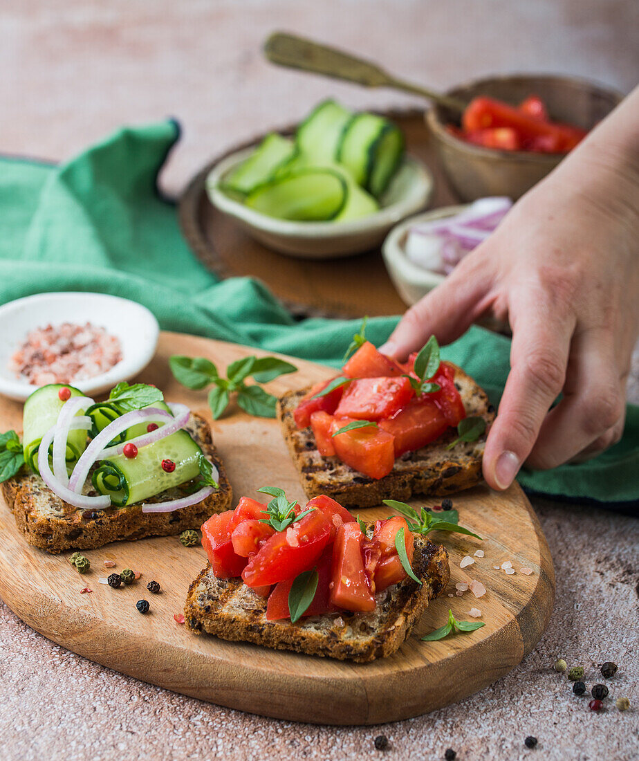 Gegrillte Brotscheiben mit frischen Tomaten, Gurken und roten Zwiebeln