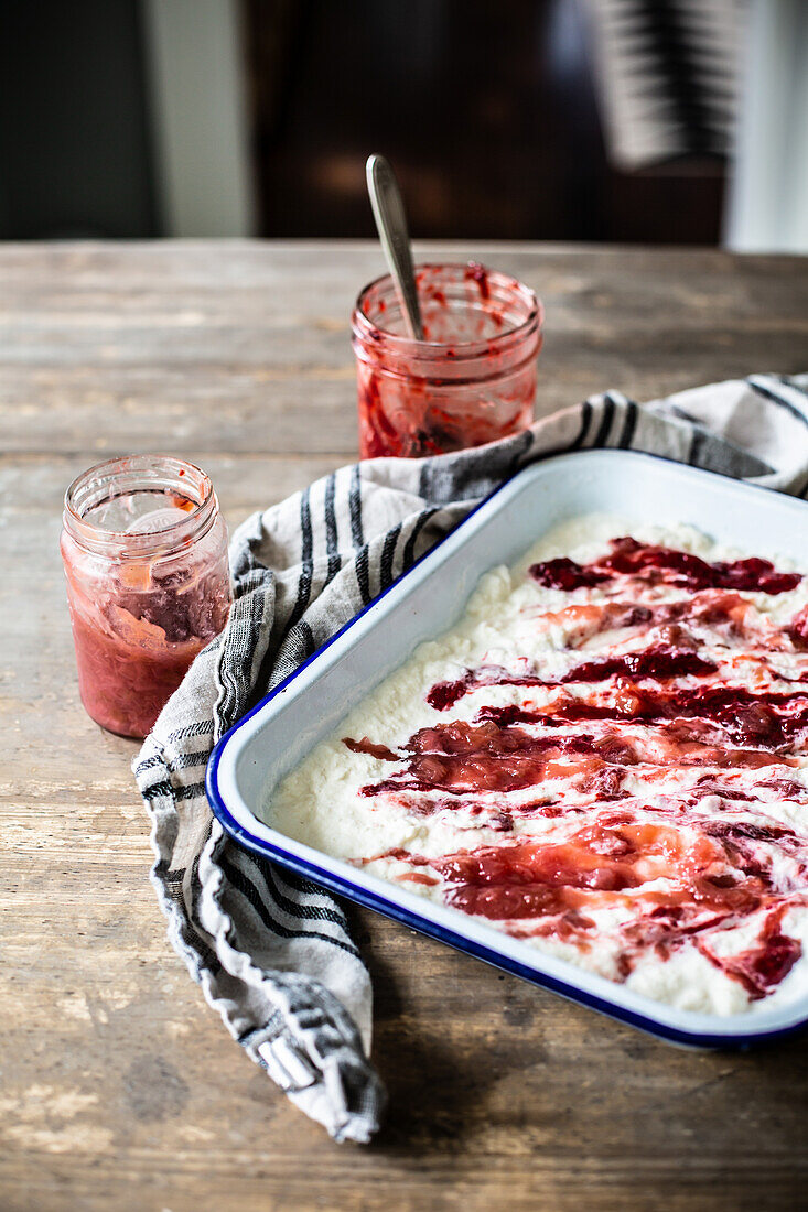 Ice cream dessert with summer berry puree in a casserole dish