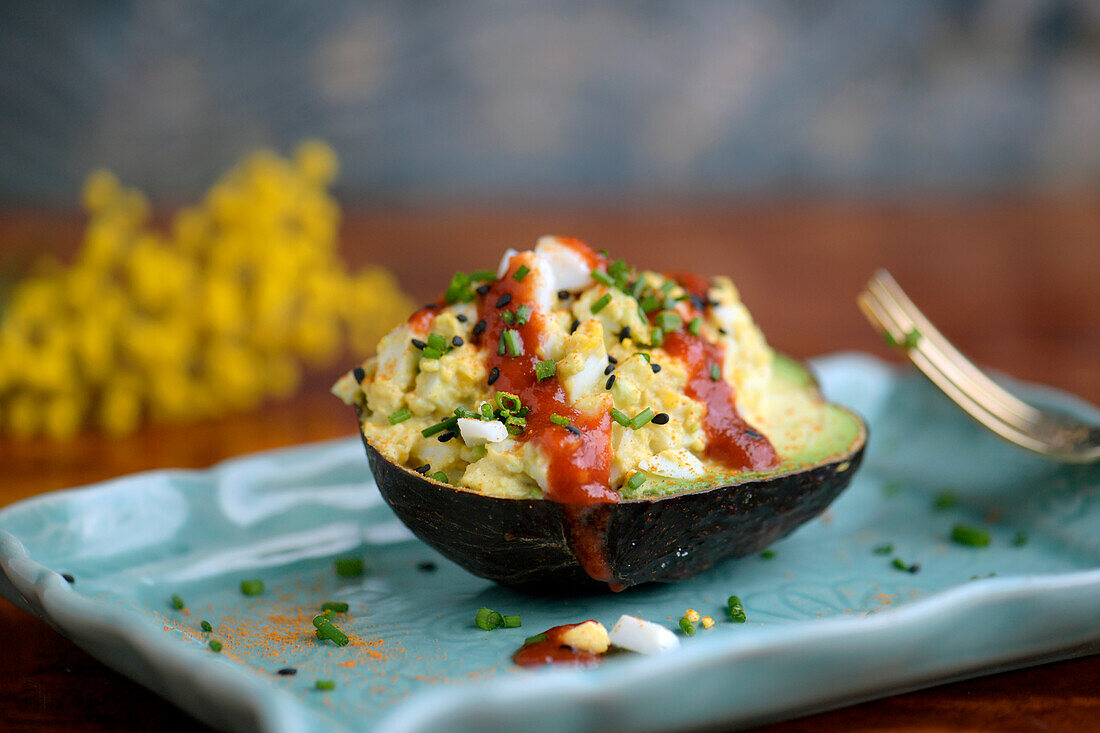 Avocado stuffed with mash consisting of eggs, mayonnaise and spices