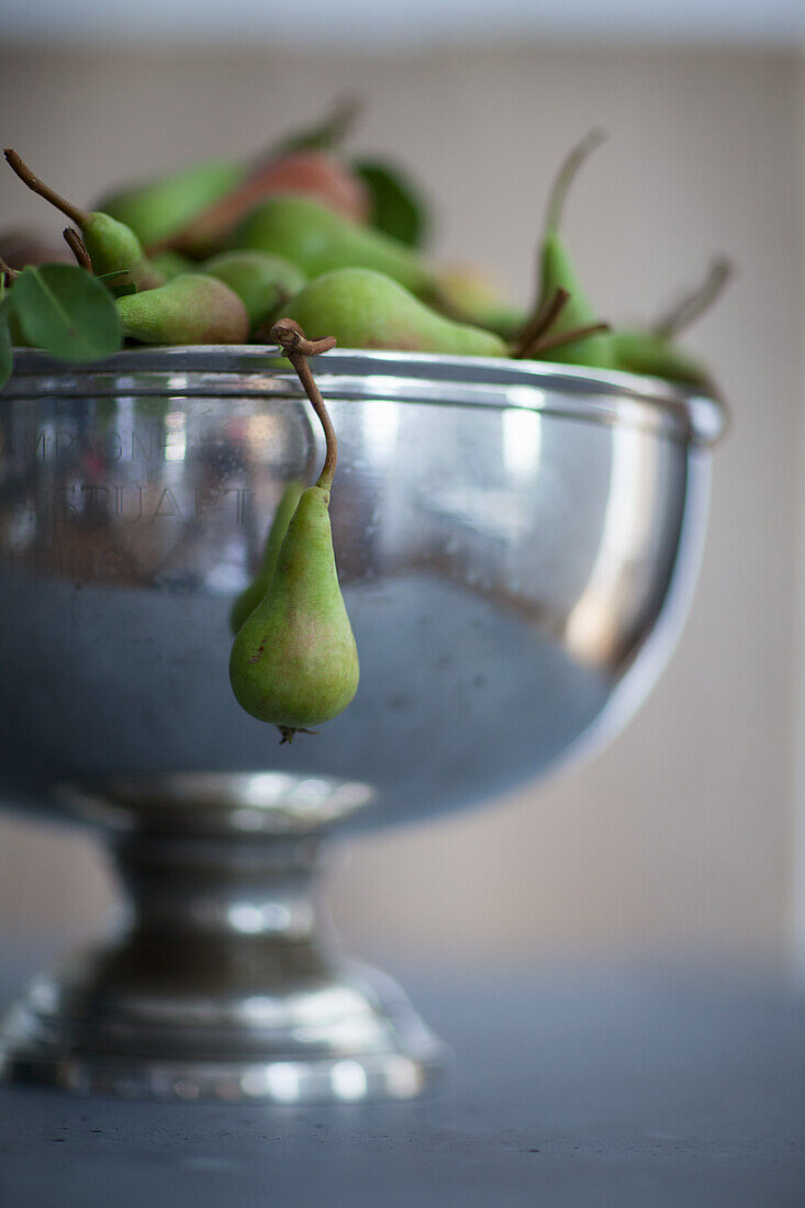 Small green pears in a metal bowl