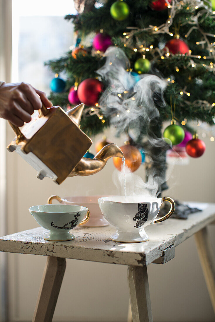 Tee in eleganten Teetassen unterm Weihnachtsbaum