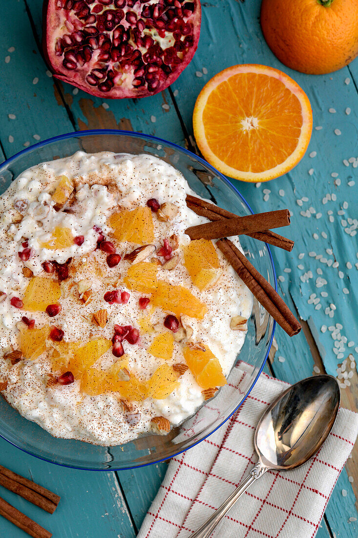Rice pudding with pomegranate seeds, oranges and cinnamon