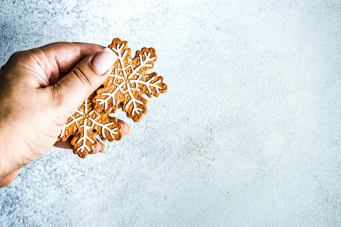 Woman hand holds Christmas cookies on the concrete background