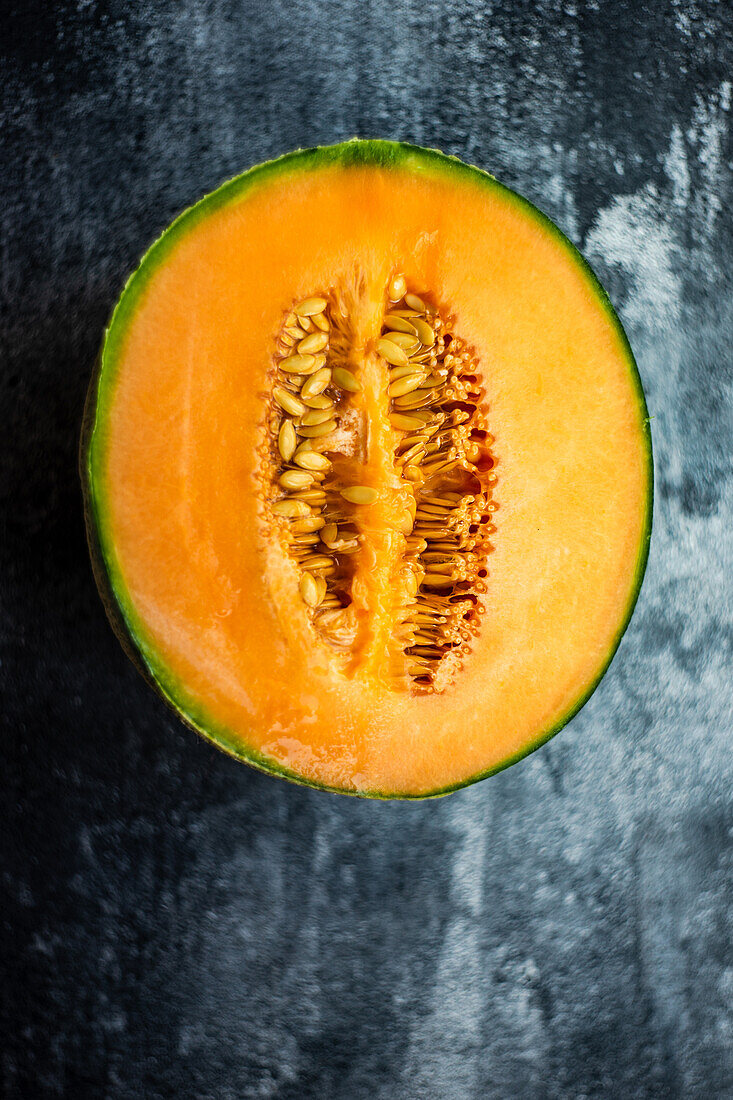 Reife Cantaloupe-Melonenhälfte auf Betonhintergrund