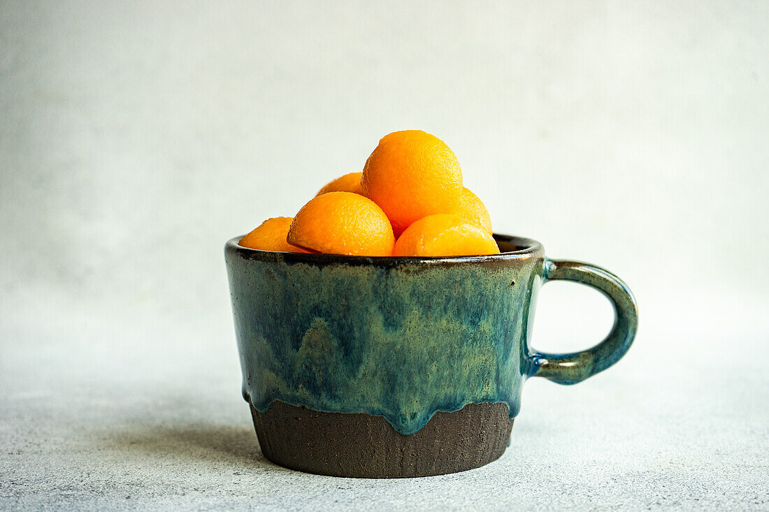 Balls of ripe cantaloupe melon in a ceramic cup