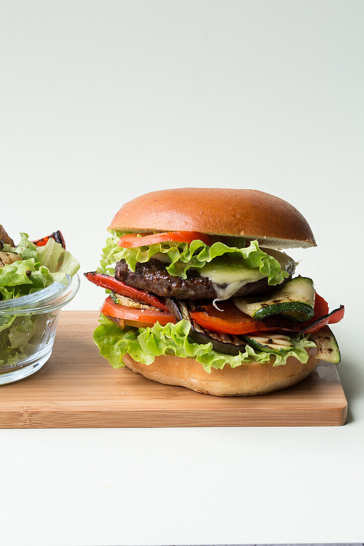 Hamburger with zucchini, tomato, and salad