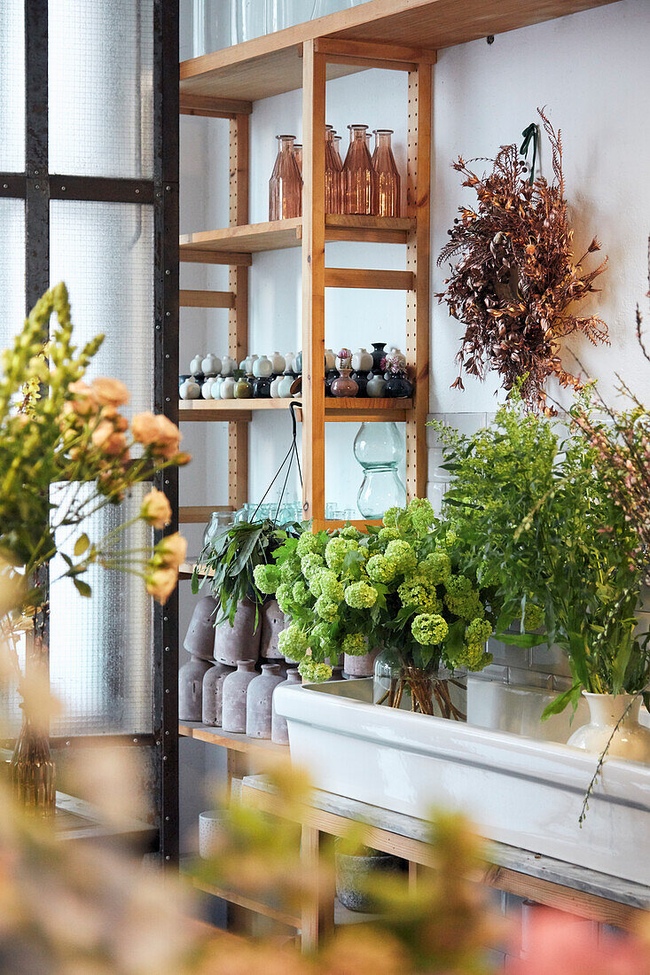 Shelf with vase collection and bouquets as an interior decoration