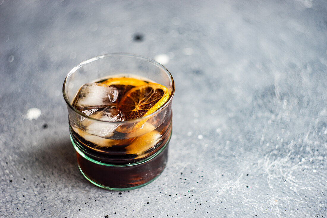 Crown and Coke (whiskey cola) with orange slice and ice cubes