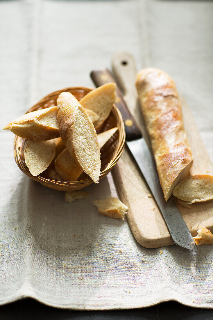 Baguette, on a cutting board and in a bread basket