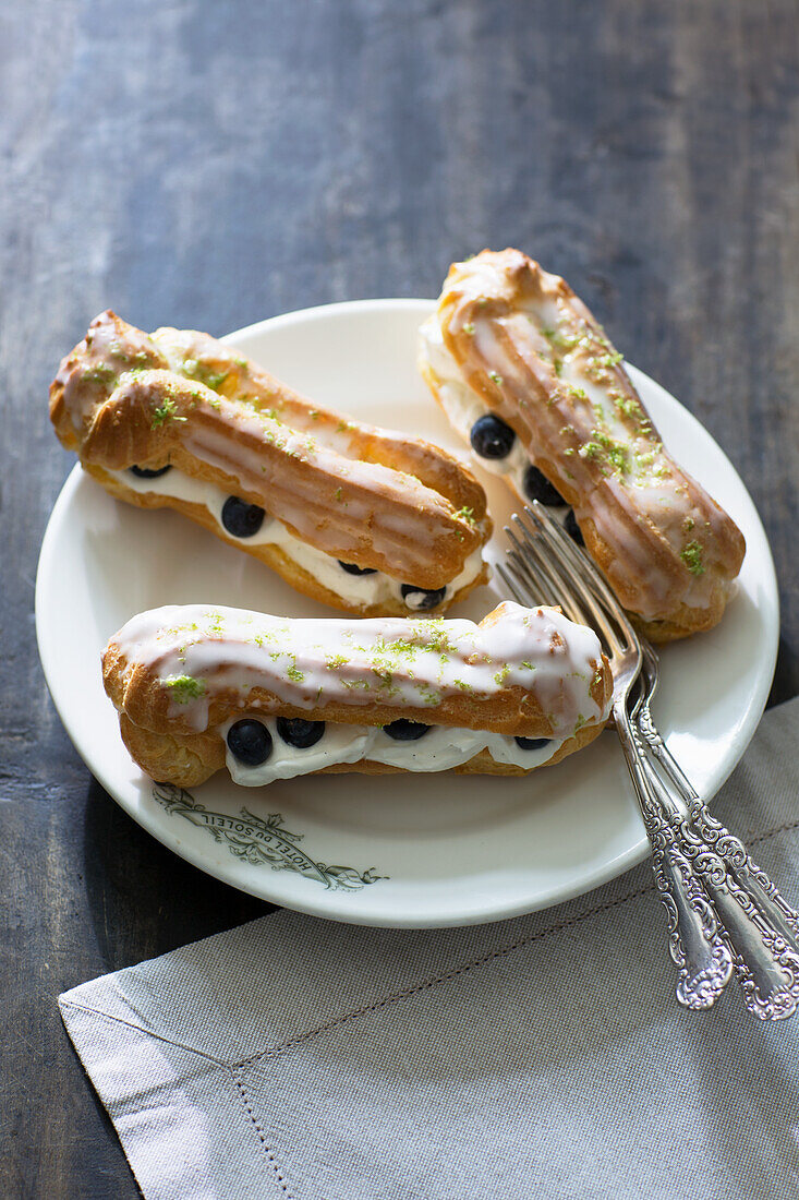 Eclaires with cream, blueberries, and sugar glaze
